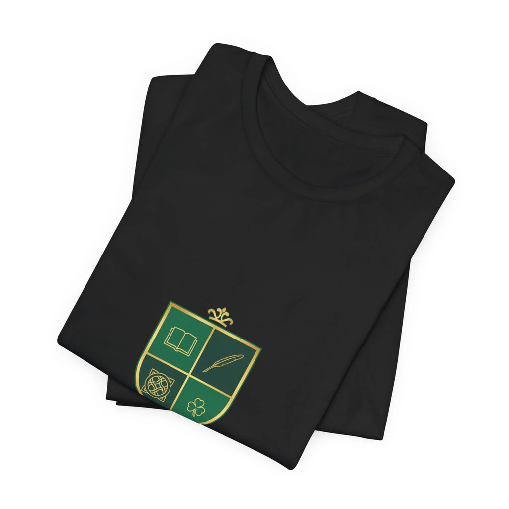 Folded black t-shirt with green and gold crest featuring book, quill, knot, and clover symbols