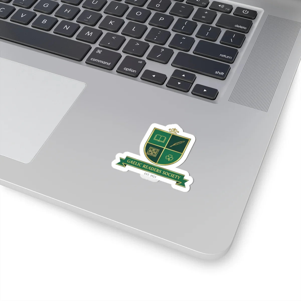 Gaelic Readers Society green crest sticker on a silver laptop near keyboard